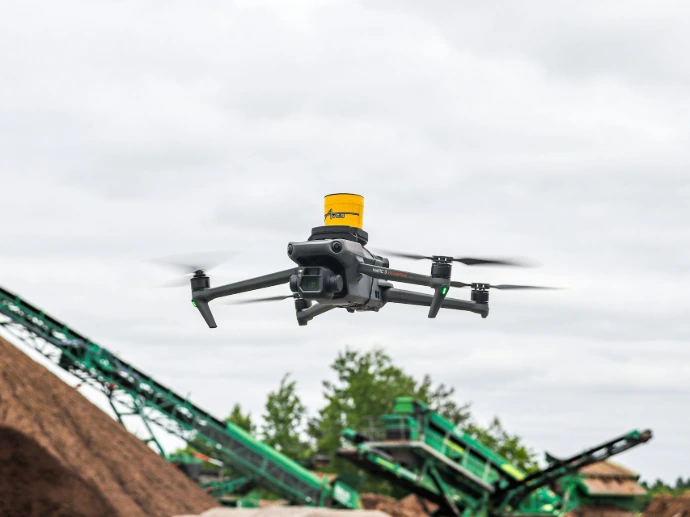 A large pile of dirt next to a green machine